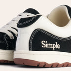 Black and white canvas sneakers with cream laces and rubber soles for casual wear.