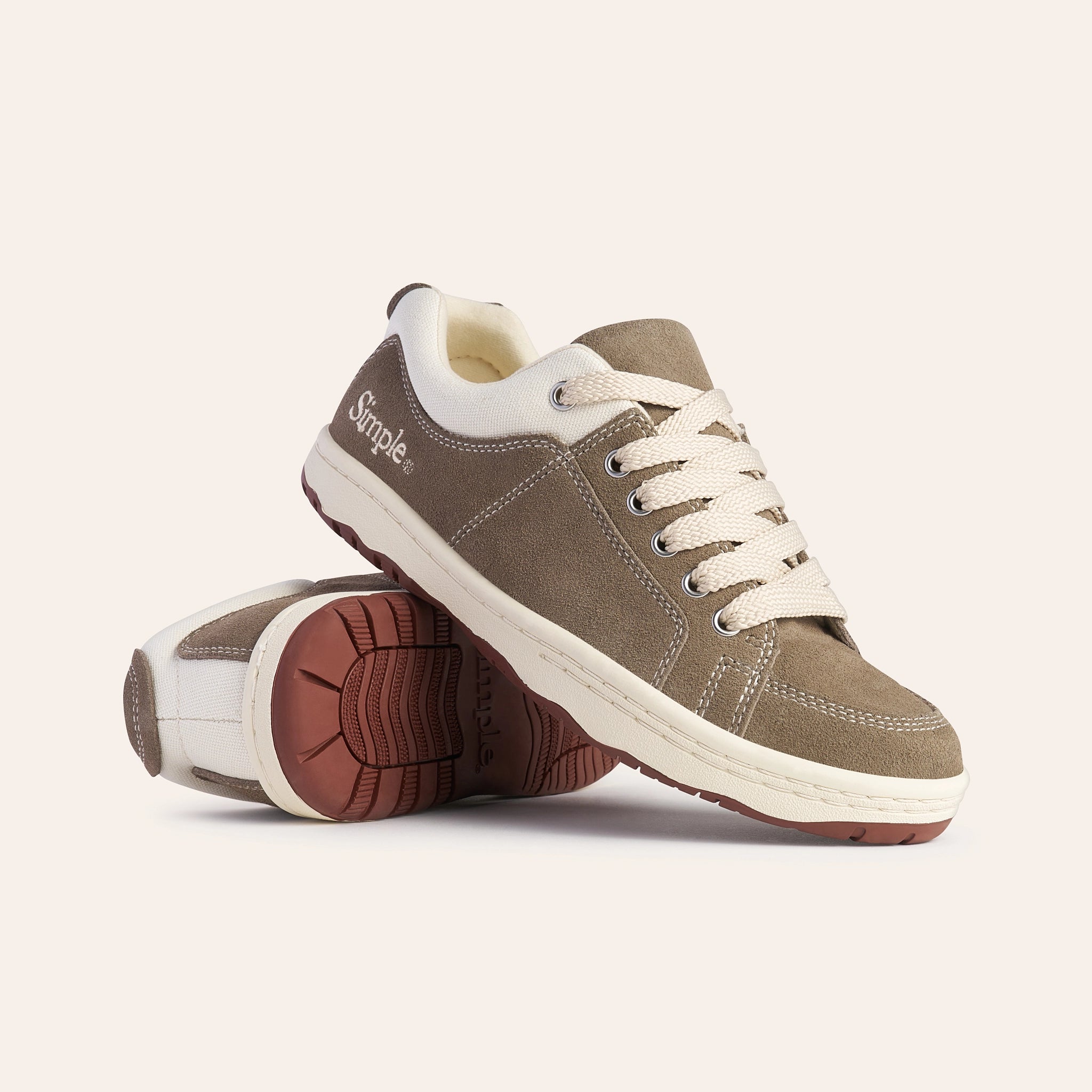 Simple brown suede sneakers with white laces and rubber sole, perfect for casual wear.