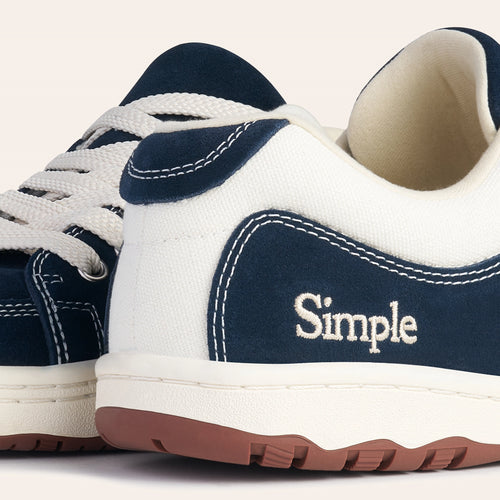 Navy blue canvas sneakers with white accents and Simple logo, featuring durable rubber sole and stylish design.