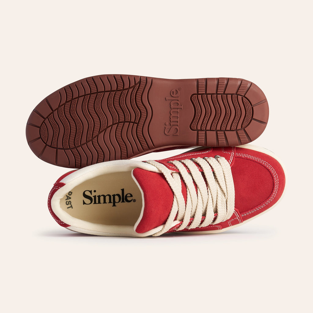 Red suede sneakers with cream laces and cushioned insole, featuring durable rubber outsole.