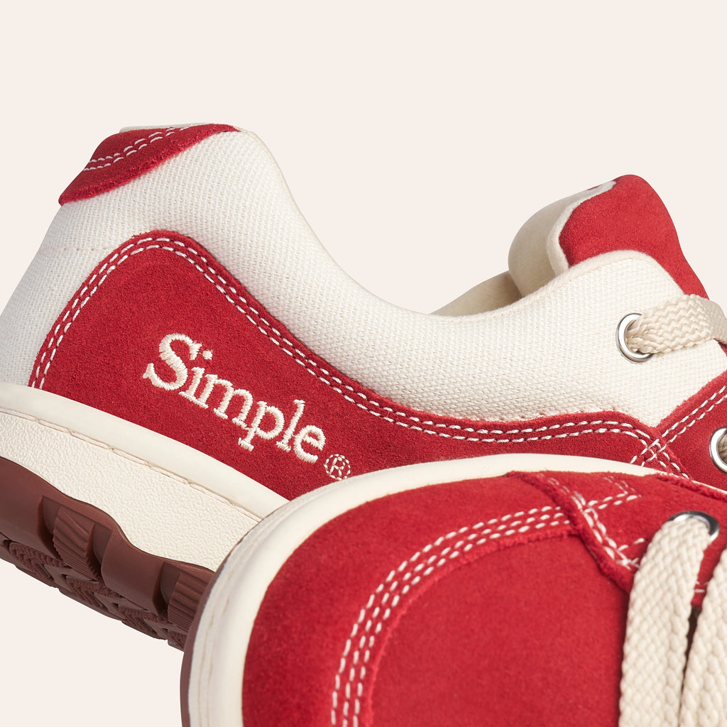 Red and cream canvas sneakers from Simple with classic design and lace-up feature.