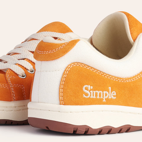 Casual suede sneakers in orange and cream with white laces and 'Simple' logo on the side.