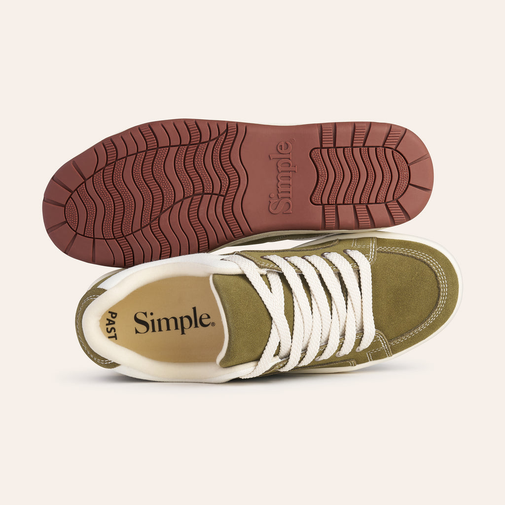 Olive green casual sneakers with white laces and a textured red rubber sole.