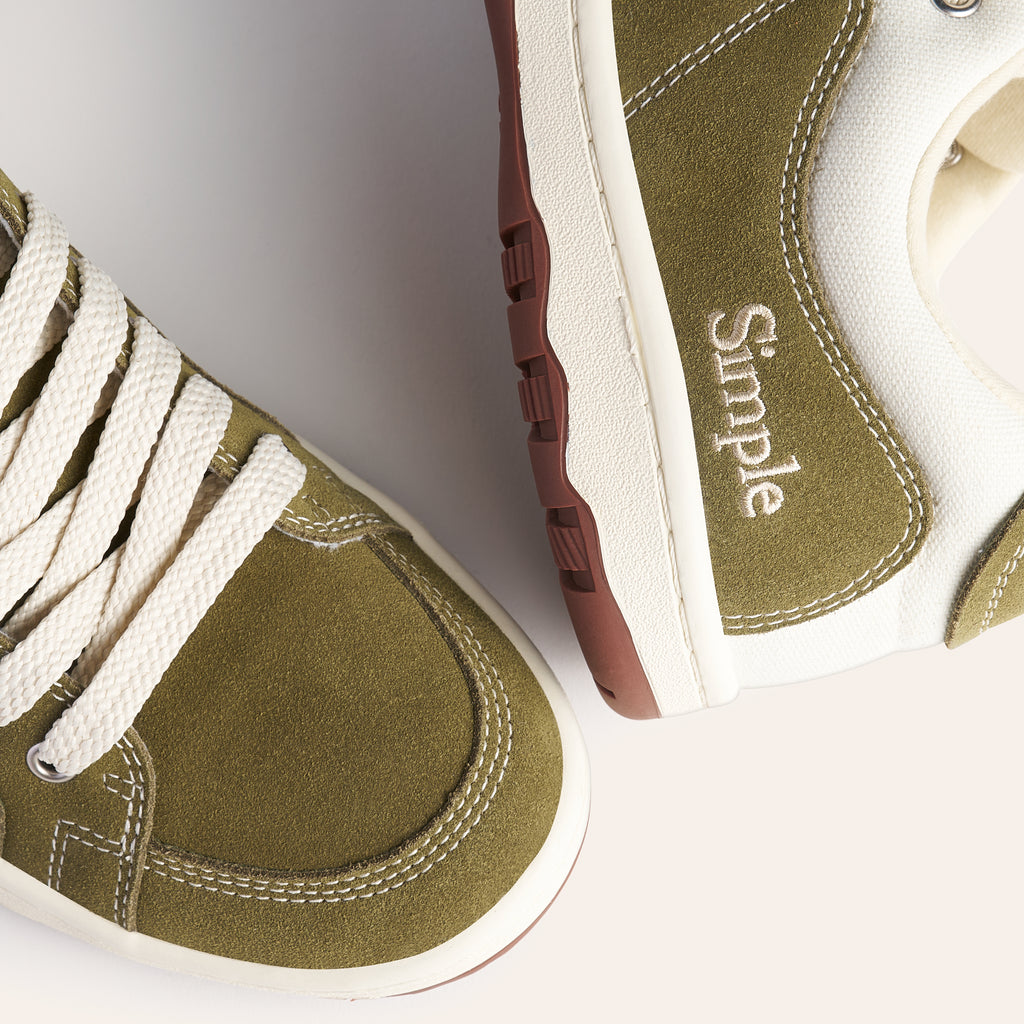 Olive green suede sneakers with cream accents and white laces by Simple, featuring a comfortable sole.