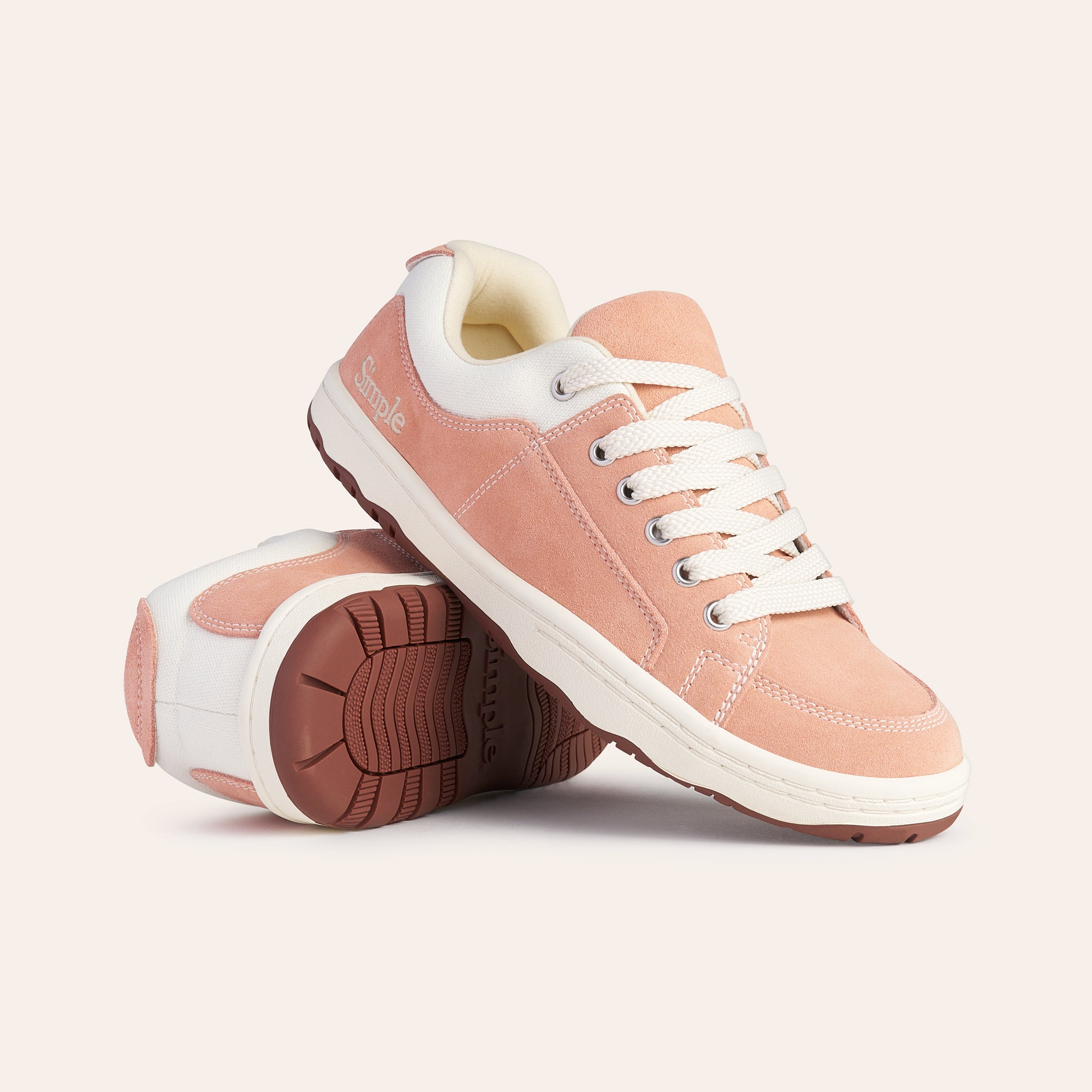 Pink suede sneakers with white laces and rubber sole, perfect for casual wear or athletic activities.