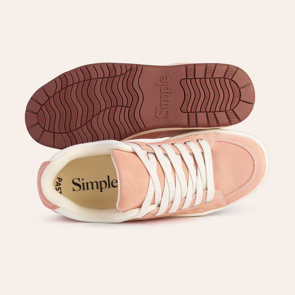 Pink suede sneakers with white laces and rubber sole, featuring a comfortable design by Simple.