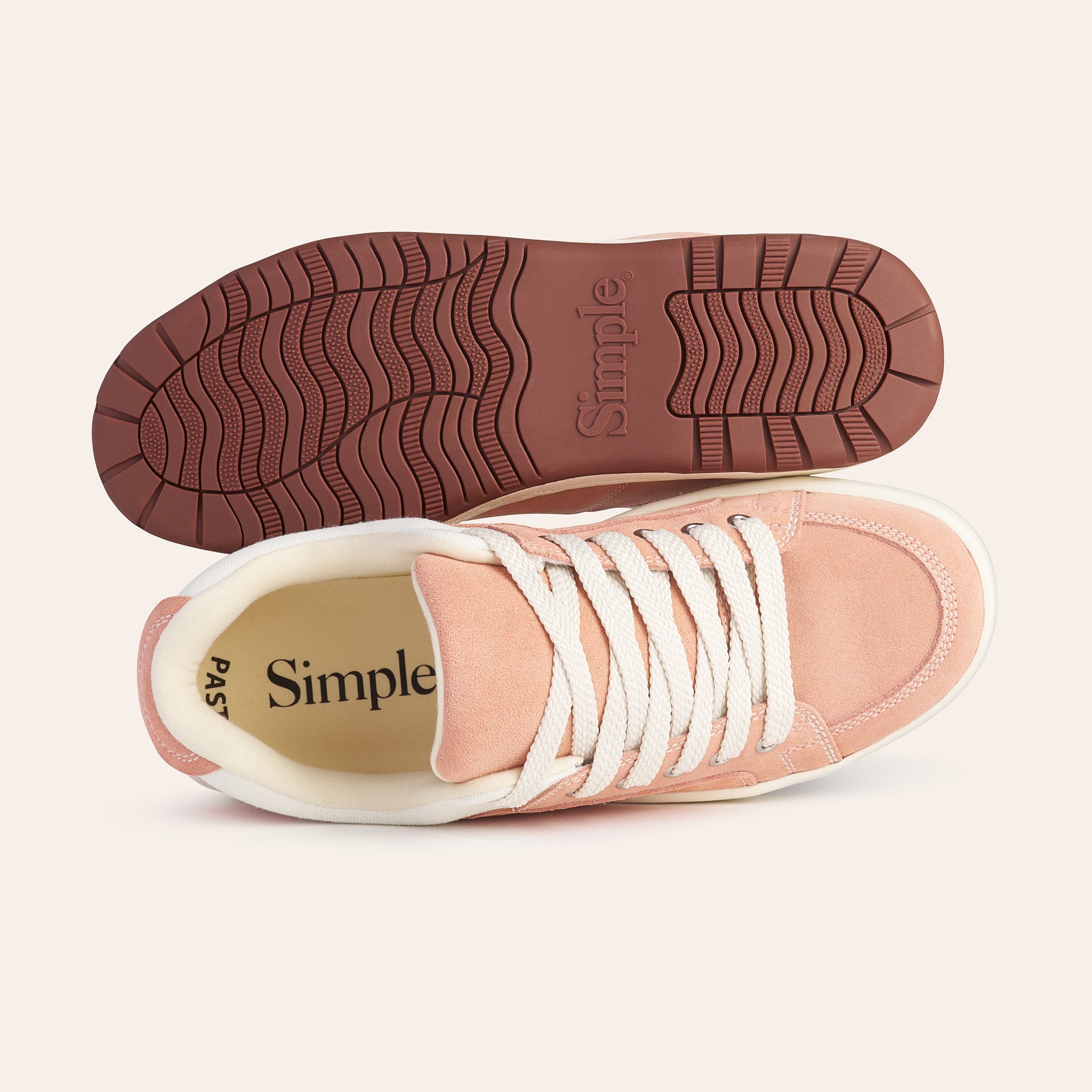 Pink suede sneakers with white laces and rubber sole, featuring a comfortable design by Simple.
