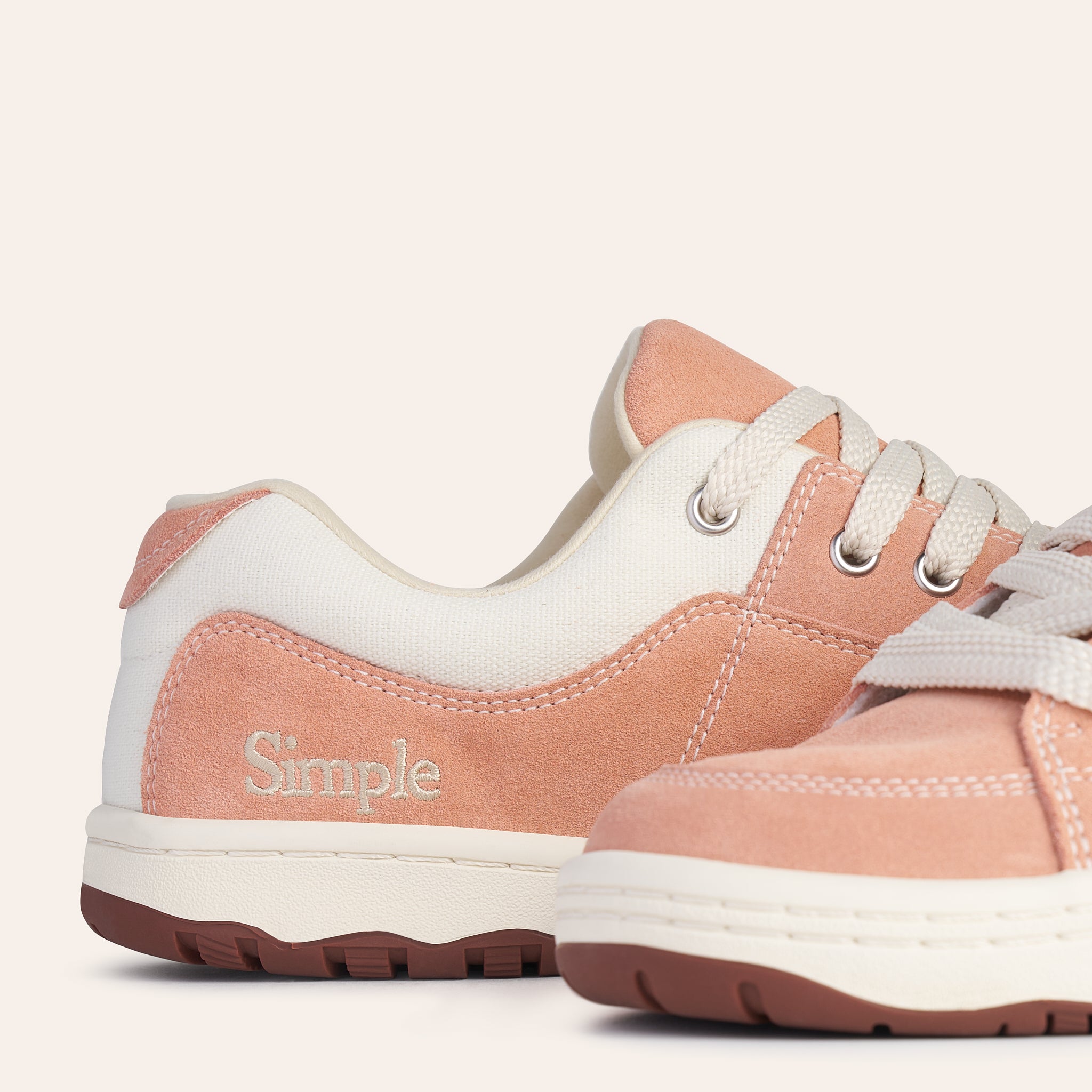 Pink suede and canvas sneakers with lace-up design and Simple branding for casual wear.