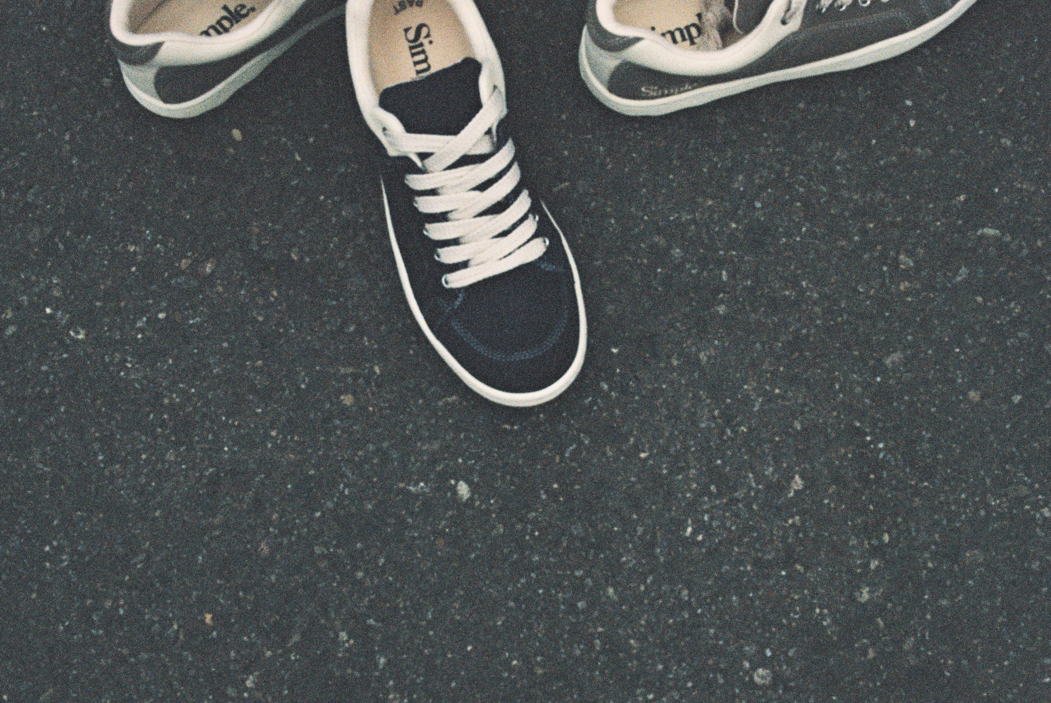 Black and white sneakers on a dark asphalt surface